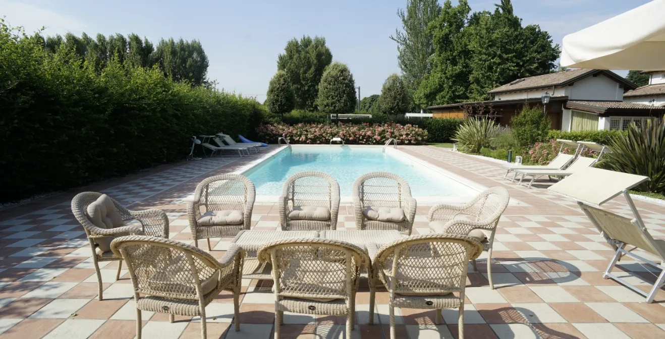 Una piscina con acqua azzurra limpida circondata dal verde